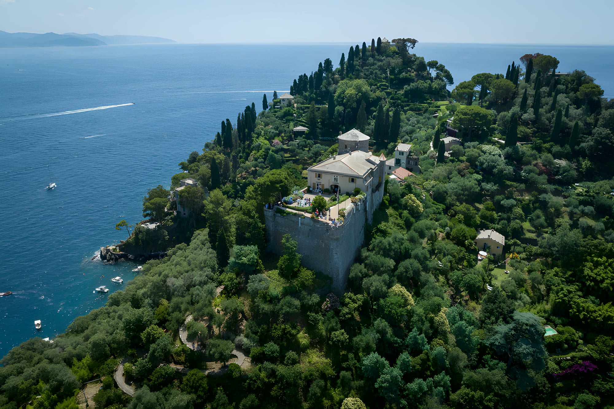 Veduta aerea del promontorio di Portofino, fra i pini fitti e il Castello Brown sopra il mare