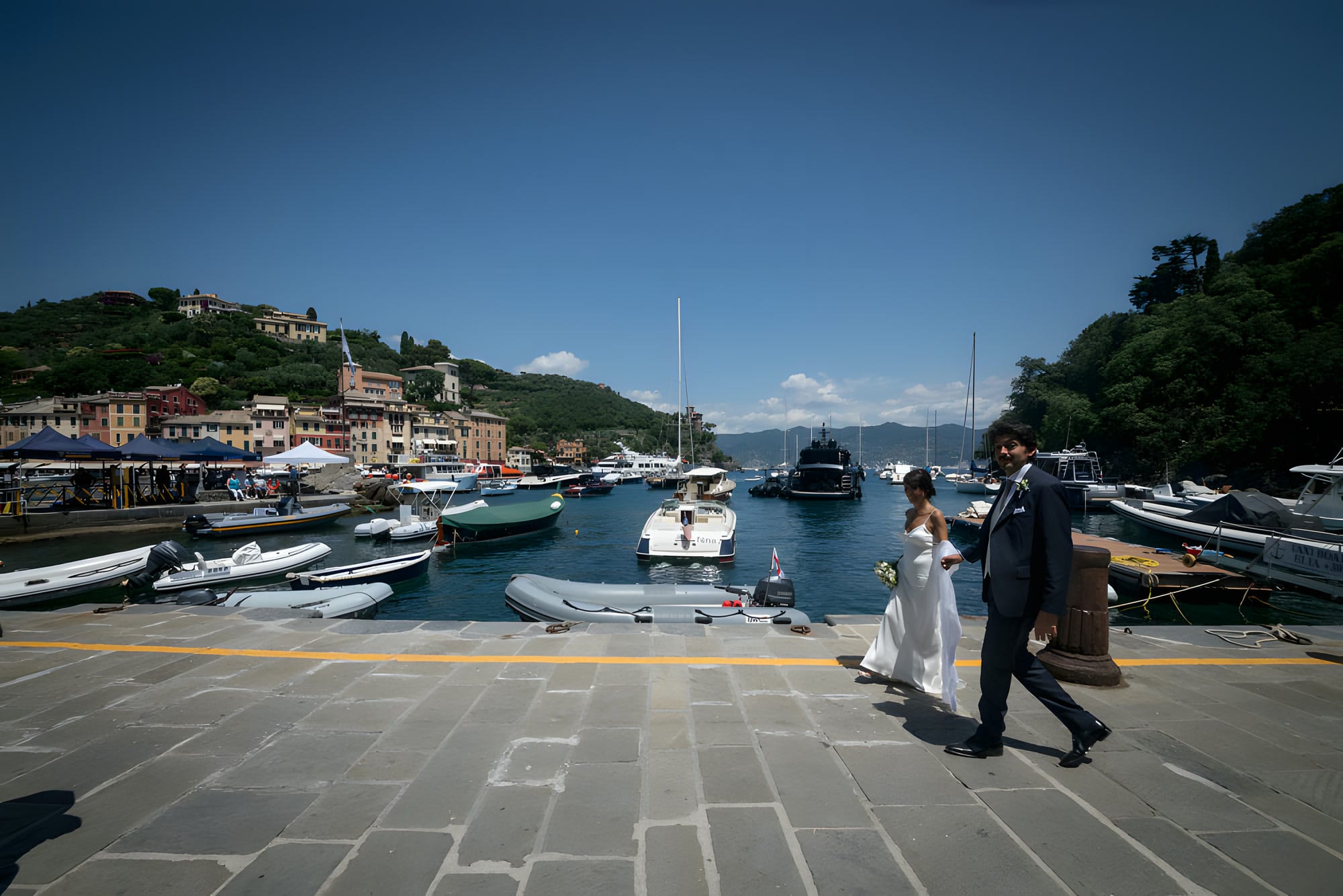 Gli sposi camminano lungo la banchina del porto di Portofino